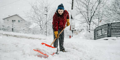 Mann beim Schneeschaufeln