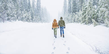 Mann und Frau spazieren im Schnee